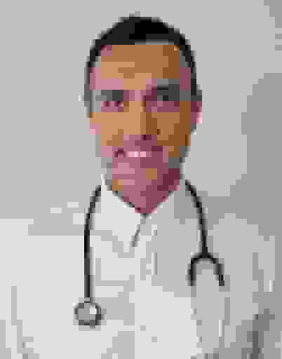 A man in a white shirt with a stethoscope against a plain light background