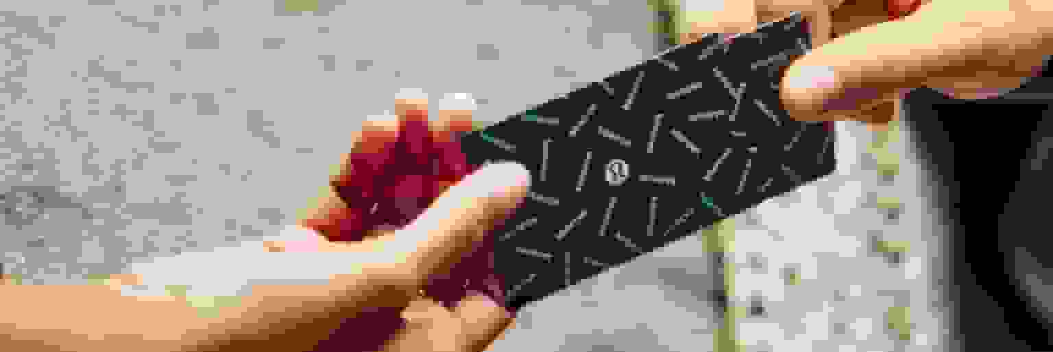 One person handing a lululemon gift card to another