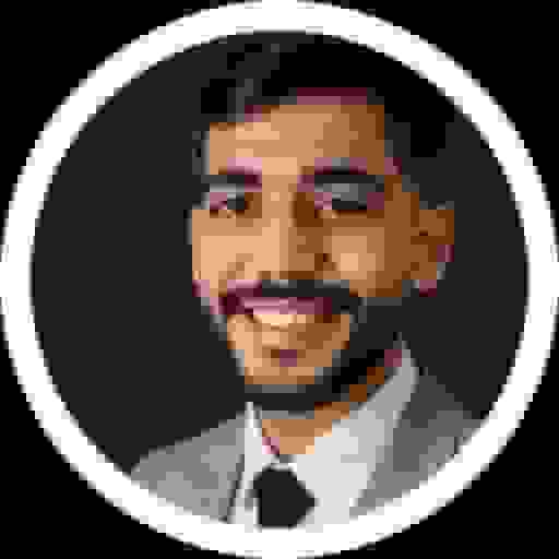 Round profile picture of a smiling bearded man in a grey blazer and dark tie, on a black background with a light grey border