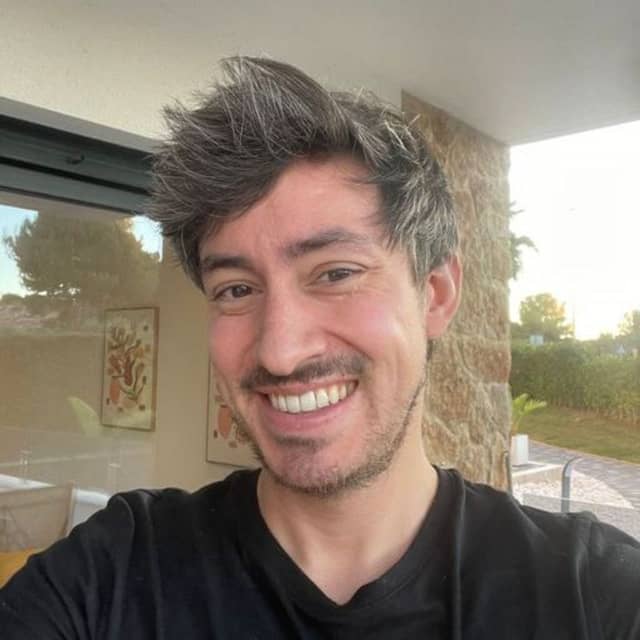 Input photo 3: selfie in the same living room, wide open smile, backlit by a window