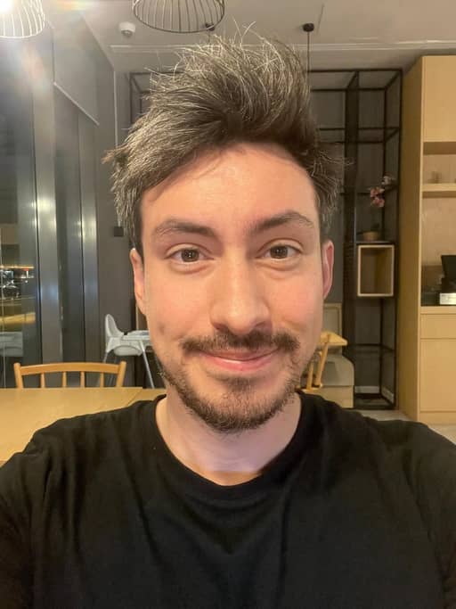 Input photo 8: selfie in a dining room in a black t-shirt under warm indoor light