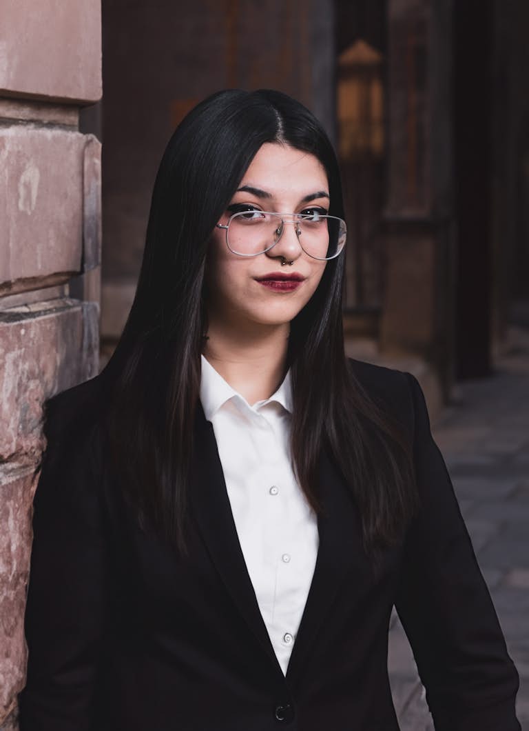 professional headshot of a white girl with black suit and glasses